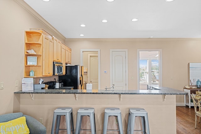 6236 Thomas Dr, Panama City Beach, FL 32408 - kitchen with ornamental molding, appliances with stainless steel finishes, open shelves, a kitchen bar, and dark wood-style floors