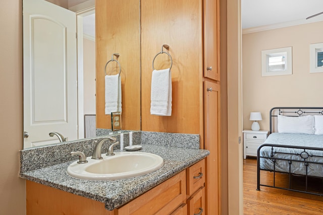 6236 Thomas Dr, Panama City Beach, FL 32408 - bathroom featuring crown molding, wood finished floors, and vanity