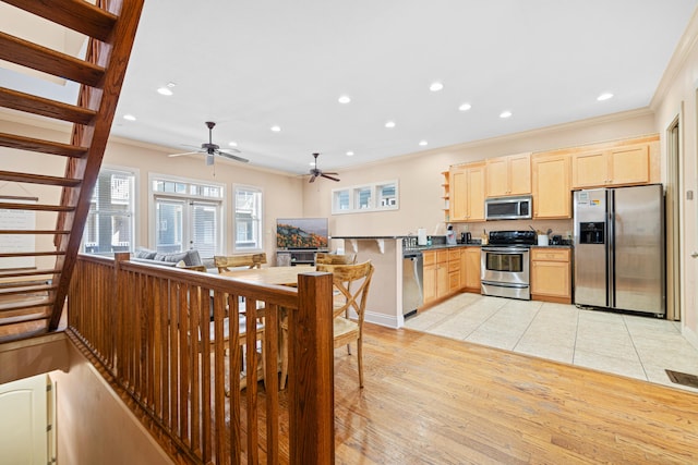 6236 Thomas Dr, Panama City Beach, FL 32408 - kitchen with appliances with stainless steel finishes, light brown cabinets, ornamental molding, light wood finished floors, and ceiling fan