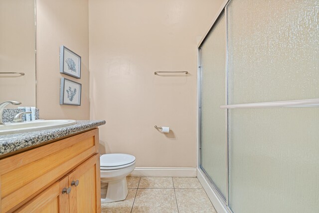 6236 Thomas Dr, Panama City Beach, FL 32408 - bathroom featuring tile patterned floors, an enclosed shower, toilet, vanity, and baseboards