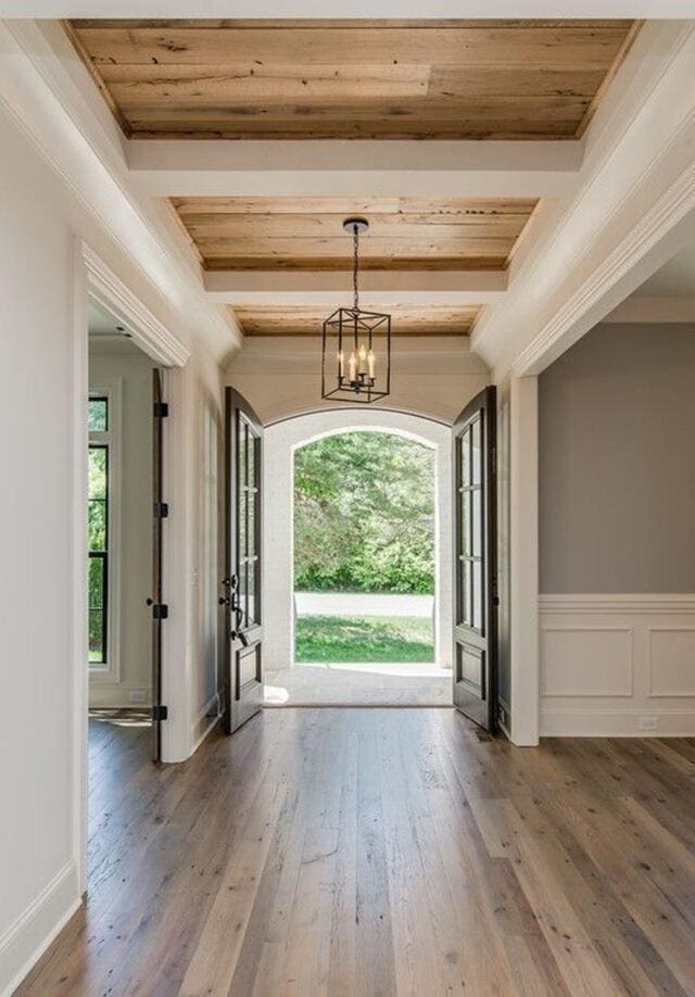 3733 Tiger Point Blvd, Gulf Breeze, FL 32563 - foyer entrance with hardwood / wood-style floors, a chandelier, beamed ceiling, and ornamental molding