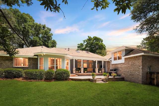 2009 Kildare Cir, Niceville, FL 32578 - back of property featuring a lawn, brick siding, a patio area, and a sunroom