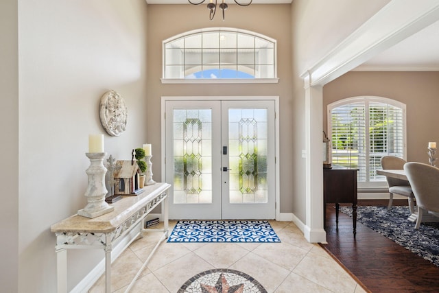 2009 Kildare Cir, Niceville, FL 32578 - entrance foyer featuring french doors, baseboards, light tile patterned floors, ornamental molding, and a towering ceiling