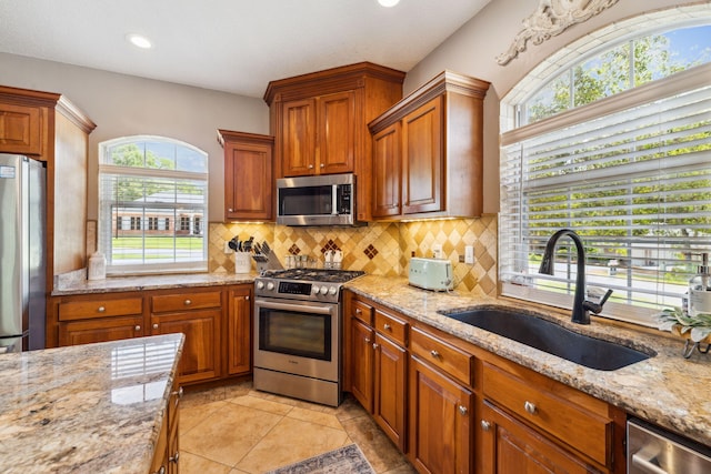 2009 Kildare Cir, Niceville, FL 32578 - kitchen with stainless steel appliances, a sink, backsplash, light stone counters, and plenty of natural light
