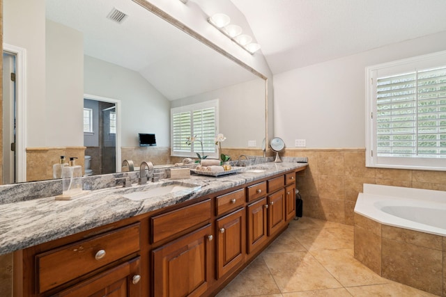 2009 Kildare Cir, Niceville, FL 32578 - full bath featuring lofted ceiling, tile patterned floors, tile walls, double vanity, and healthy amount of natural light