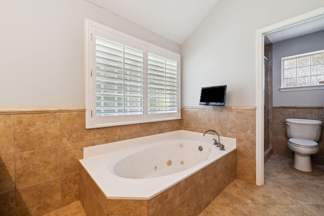 2009 Kildare Cir, Niceville, FL 32578 - bathroom with a tub with jets, toilet, tile walls, lofted ceiling, and a wainscoted wall