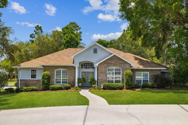 2009 Kildare Cir, Niceville, FL 32578 - view of front of house featuring french doors, a front yard, brick siding, and roof with shingles