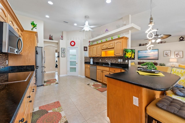 2424 Pineneedle Dr, Navarre, FL 32566 - kitchen featuring stainless steel appliances, a ceiling fan, a kitchen breakfast bar, open floor plan, and light tile patterned floors