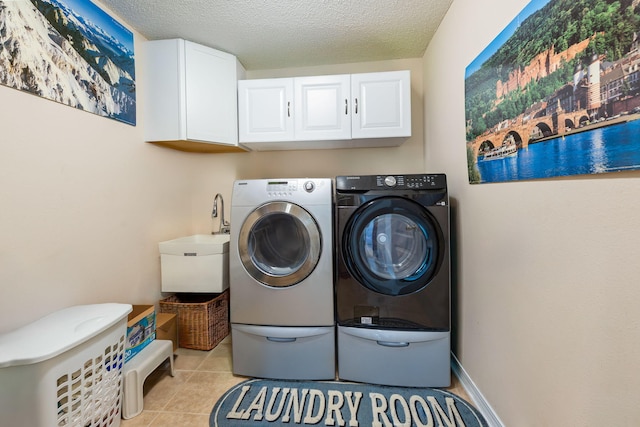 2424 Pineneedle Dr, Navarre, FL 32566 - washroom featuring cabinet space, washing machine and clothes dryer, light tile patterned floors, and a textured ceiling