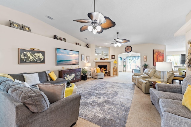 2424 Pineneedle Dr, Navarre, FL 32566 - living room with carpet, a ceiling fan, vaulted ceiling, and a warm lit fireplace