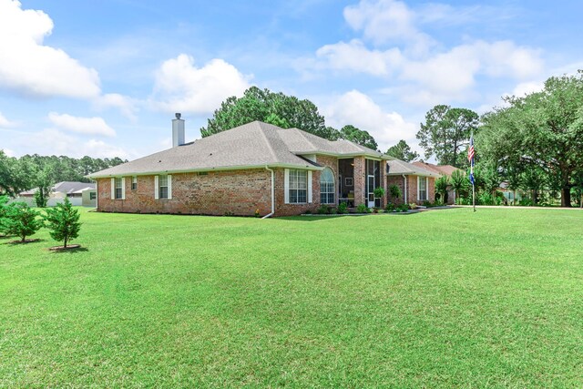 2424 Pineneedle Dr, Navarre, FL 32566 - back of property with a yard, a chimney, and brick siding