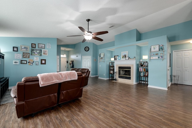 104 Sandstone Trl, Crestview, FL 32539 - living area with vaulted ceiling, ceiling fan, wood finished floors, a tile fireplace, and a textured ceiling