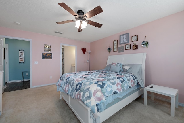 104 Sandstone Trl, Crestview, FL 32539 - bedroom featuring light carpet, baseboards, a ceiling fan, and ensuite bath