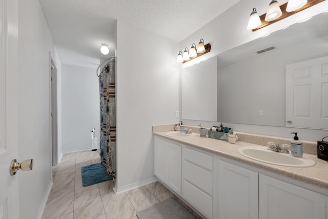 104 Sandstone Trl, Crestview, FL 32539 - bathroom with double vanity, a textured ceiling, baseboards, and marble finish floors