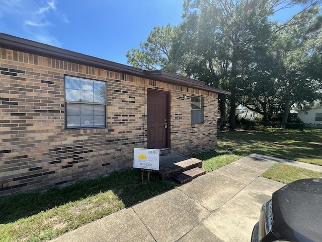 816 Lark St Unit 5, 6, 7, 8, Fort Walton Beach, FL 32547 - doorway to property with a lawn and brick siding