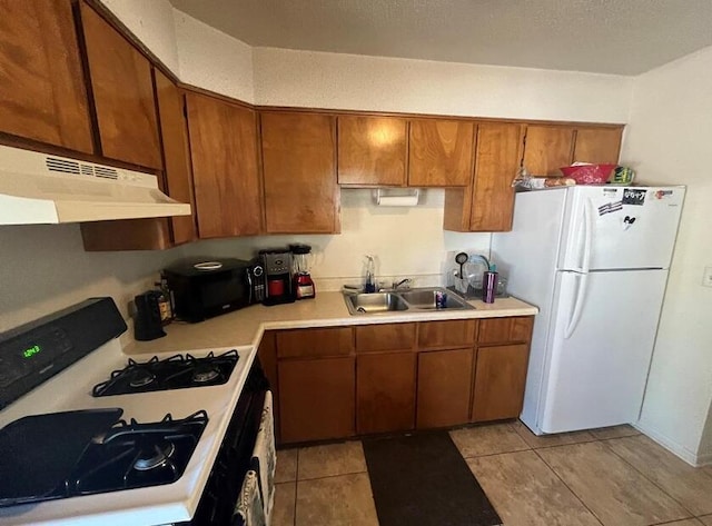 816 Lark St Unit 5, 6, 7, 8, Fort Walton Beach, FL 32547 - kitchen with under cabinet range hood, freestanding refrigerator, gas stove, black microwave, and light countertops