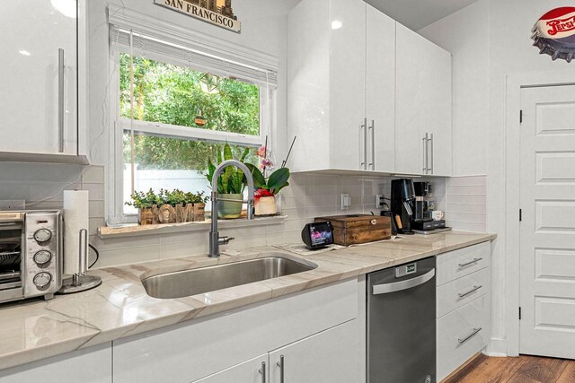 736 Commanche St, Fort Walton Beach, FL 32547 - kitchen featuring dishwasher, a sink, white cabinets, and backsplash