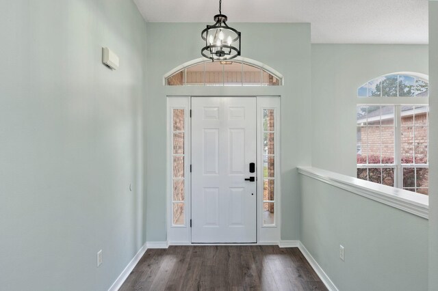 3167 Border Creek Dr, Crestview, FL 32539 - entrance foyer with a chandelier, dark wood-style flooring, and baseboards