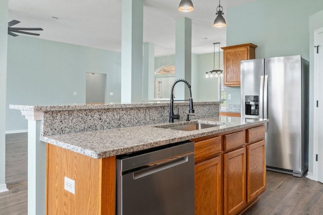 3167 Border Creek Dr, Crestview, FL 32539 - kitchen with stainless steel appliances, a sink, wood finished floors, a center island with sink, and a ceiling fan