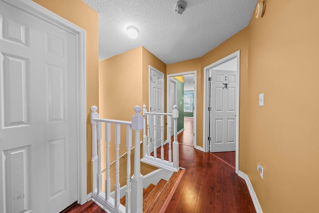 859 Mande Ct, Shalimar, FL 32579 - hall featuring an upstairs landing, a textured ceiling, wood finished floors, and baseboards