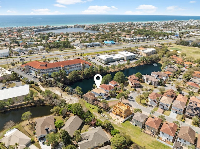 aerial view of property and surrounding area featuring a large body of water and nearby suburban area