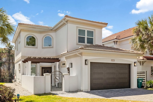 view of front of property with a tile roof, a gate, stucco siding, fence, and driveway