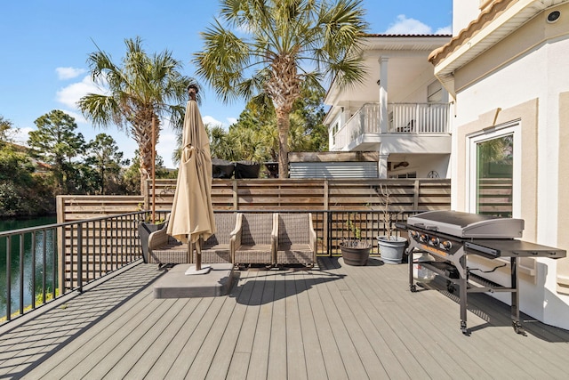 wooden deck with a water view and grilling area