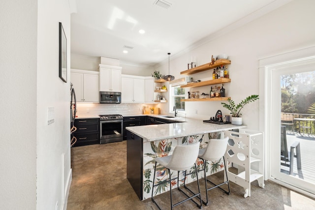 kitchen featuring stainless steel appliances, a sink, open shelves, a peninsula, and tasteful backsplash