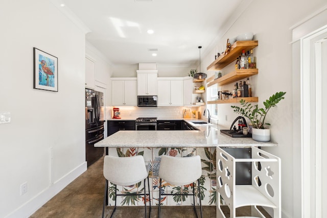 kitchen with appliances with stainless steel finishes, a sink, baseboards, a peninsula, and finished concrete flooring