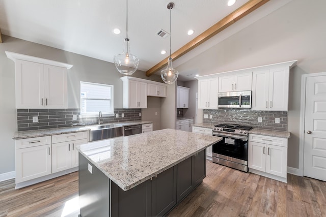 1432 Madelyn Woods Dr, Pensacola, FL 32506 - kitchen featuring stainless steel appliances, backsplash, white cabinetry, recessed lighting, and a kitchen island
