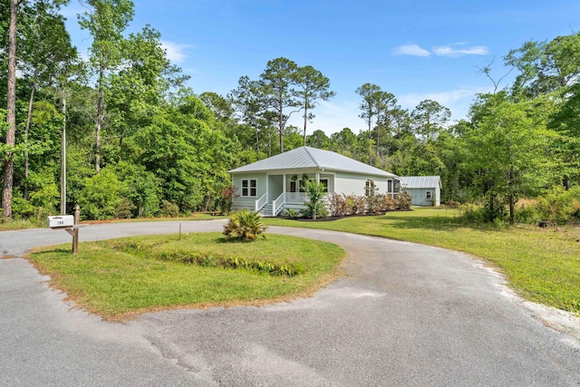 196 Summer Breeze Ln, Santa Rosa Beach, FL 32459 - view of front of house with covered porch, curved driveway, a front lawn, and metal roof
