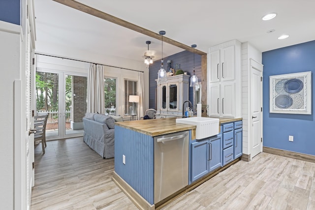 kitchen featuring wooden counters, dishwasher, blue cabinets, a sink, and light wood finished floors