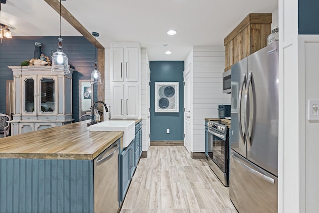 9300 Baytowne Wharf Blvd Unit 113, Miramar Beach, FL 32550 - kitchen featuring stainless steel appliances, a sink, light wood-type flooring, wooden counters, and pendant lighting