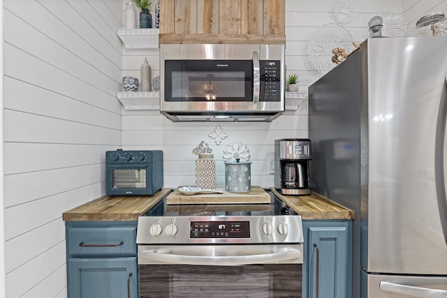 9300 Baytowne Wharf Blvd Unit 113, Miramar Beach, FL 32550 - kitchen featuring appliances with stainless steel finishes, butcher block countertops, and blue cabinetry