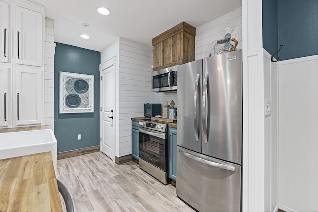 9300 Baytowne Wharf Blvd Unit 113, Miramar Beach, FL 32550 - kitchen with stainless steel appliances, wood counters, light wood-style floors, white cabinetry, and recessed lighting