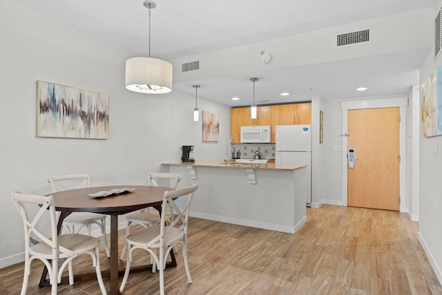 dining space featuring light wood-type flooring, baseboards, and recessed lighting