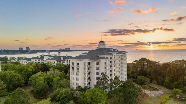 property at dusk with a water view