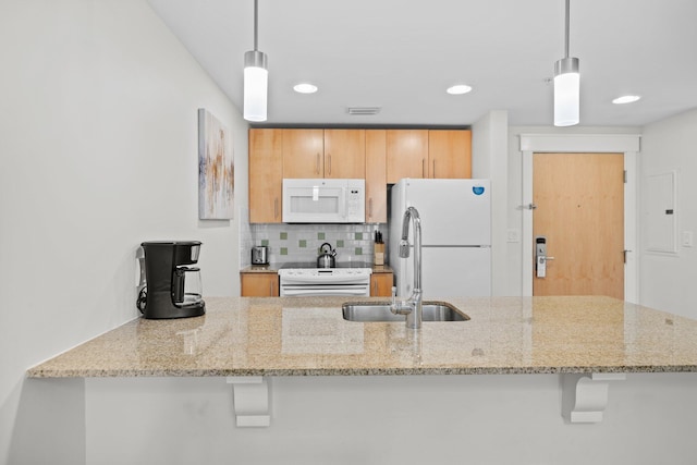 kitchen featuring white appliances, tasteful backsplash, a sink, light stone countertops, and decorative light fixtures