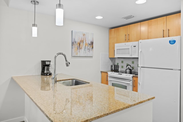 kitchen featuring white appliances, a sink, a peninsula, tasteful backsplash, and light stone countertops