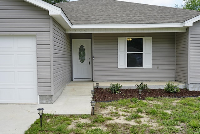 1422 Oakwood Lakes Blvd, Defuniak Springs, FL 32433 - view of exterior entry featuring an attached garage and roof with shingles