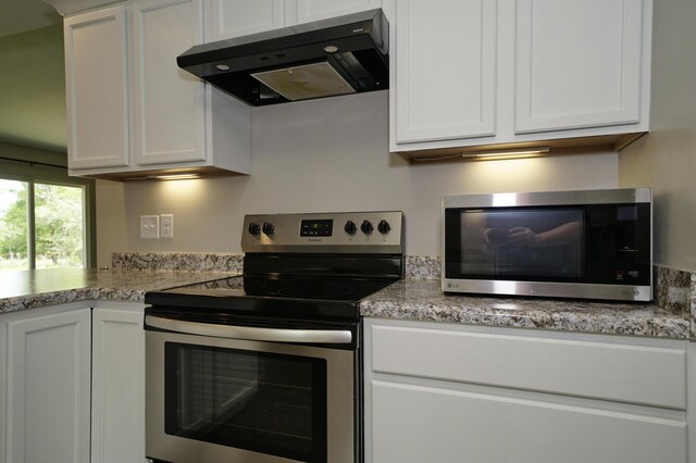 1422 Oakwood Lakes Blvd, Defuniak Springs, FL 32433 - kitchen featuring stainless steel appliances, under cabinet range hood, white cabinets, and light stone countertops