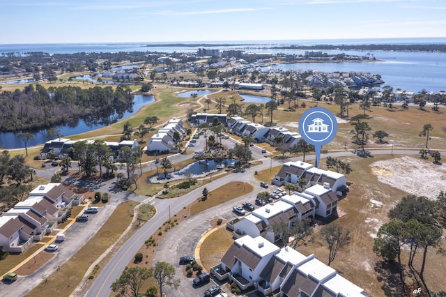 aerial view of property and surrounding area featuring a large body of water and nearby suburban area