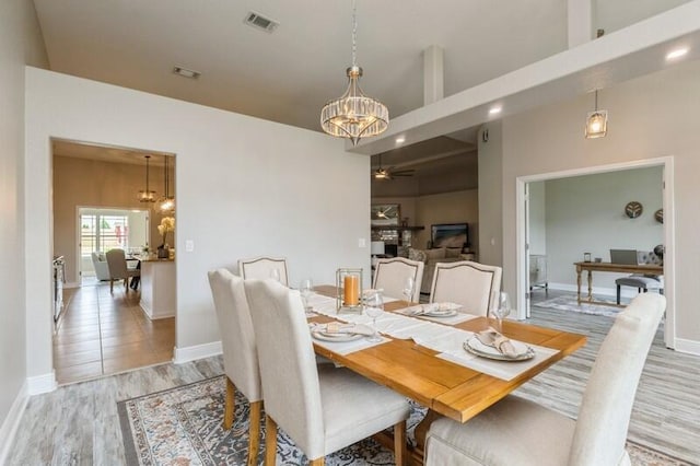 6216 Plum Orchard Way, Crestview, FL 32536 - dining room featuring a chandelier, light wood finished floors, ceiling fan, baseboards, and a high ceiling