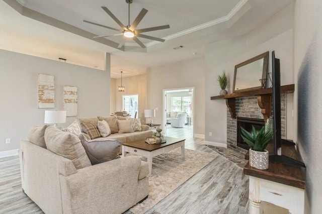 6216 Plum Orchard Way, Crestview, FL 32536 - living room featuring a raised ceiling, light wood-style flooring, baseboards, a ceiling fan, and crown molding