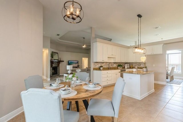 6216 Plum Orchard Way, Crestview, FL 32536 - dining area with a chandelier, light tile patterned floors, a fireplace, and baseboards