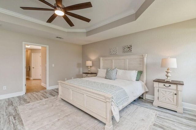 6216 Plum Orchard Way, Crestview, FL 32536 - bedroom featuring light wood finished floors, crown molding, baseboards, a tray ceiling, and a ceiling fan