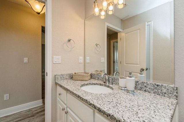 6216 Plum Orchard Way, Crestview, FL 32536 - bathroom featuring a chandelier, vanity, wood finished floors, and baseboards