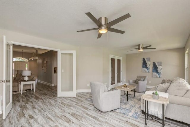 6216 Plum Orchard Way, Crestview, FL 32536 - living room with light wood finished floors, a ceiling fan, baseboards, and french doors