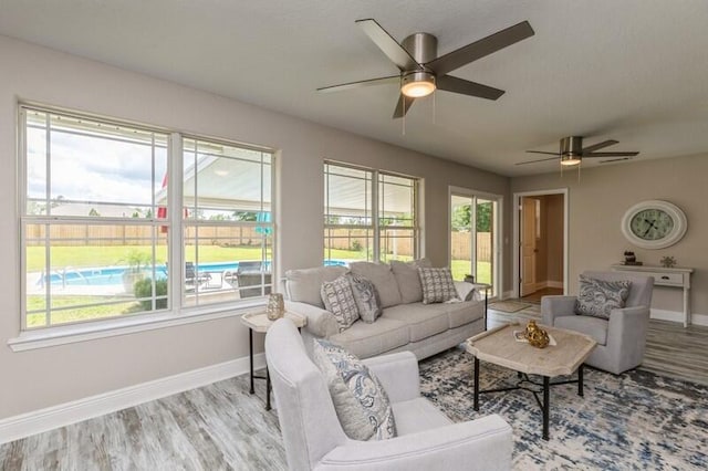 6216 Plum Orchard Way, Crestview, FL 32536 - living room featuring a ceiling fan, baseboards, wood finished floors, and plenty of natural light