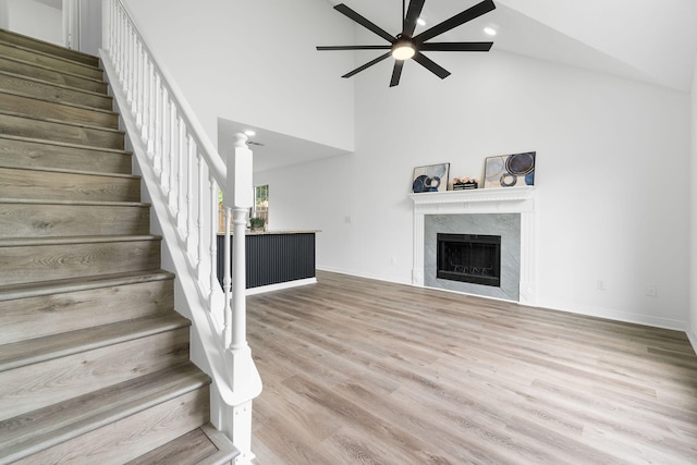 1725 Colonial Ct, Fort Walton Beach, FL 32547 - unfurnished living room featuring ceiling fan, high vaulted ceiling, a fireplace, stairway, and wood finished floors